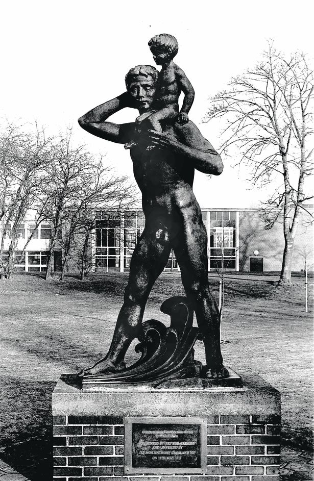 statue of boy sitting on man's shoulders